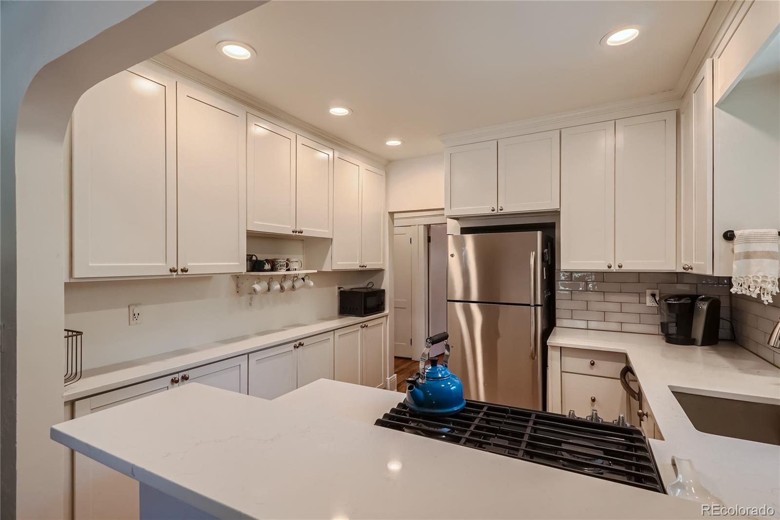 954 Monroe Street Denver, CO 80206 - Photo 12 of 28 a kitchen with a refrigerator and a sink