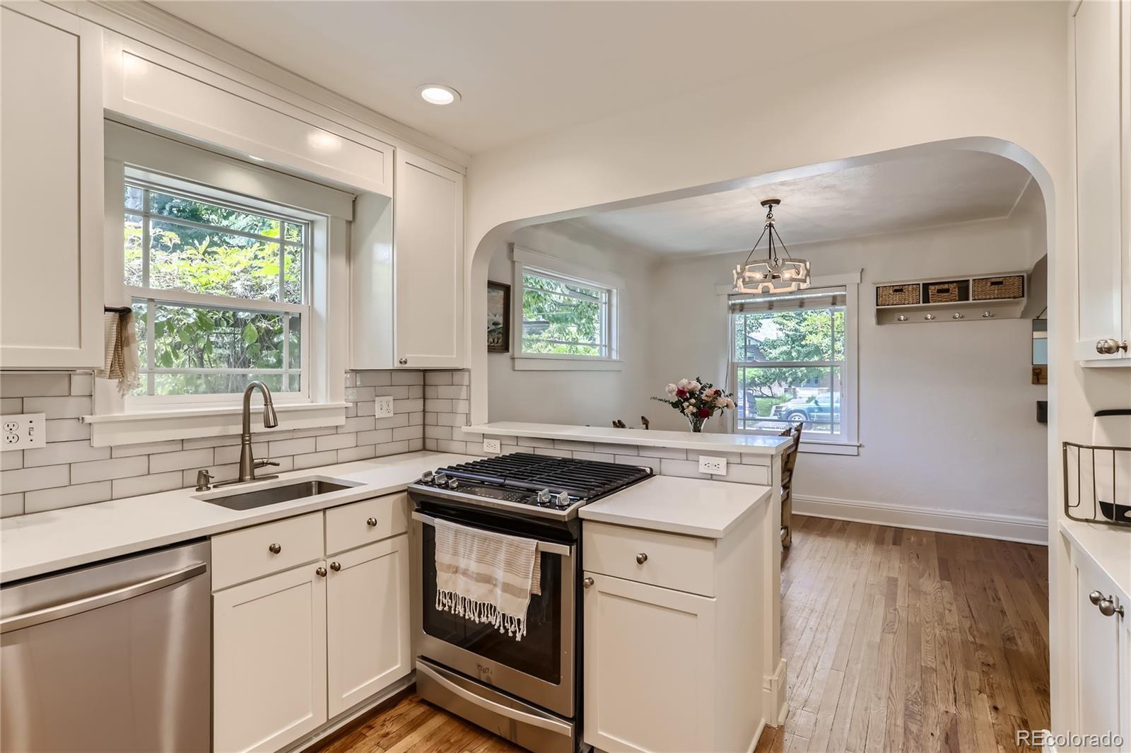 954 Monroe Street Denver, CO 80206 - Photo 13 of 28 a kitchen that has a sink a window stainless steel appliances and cabinets
