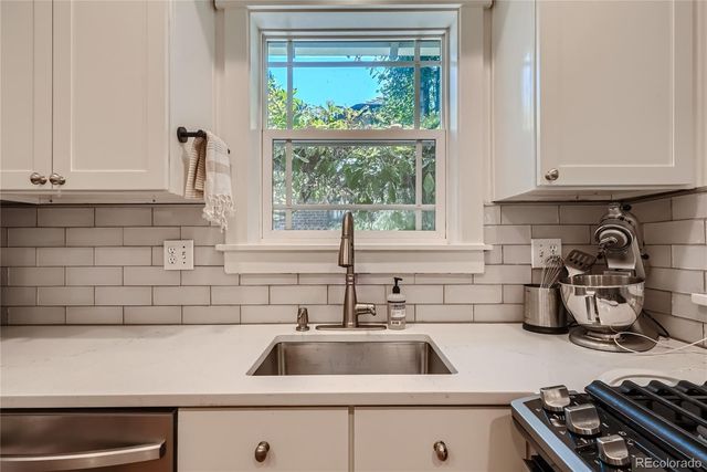a kitchen with a sink and a stove next to a window