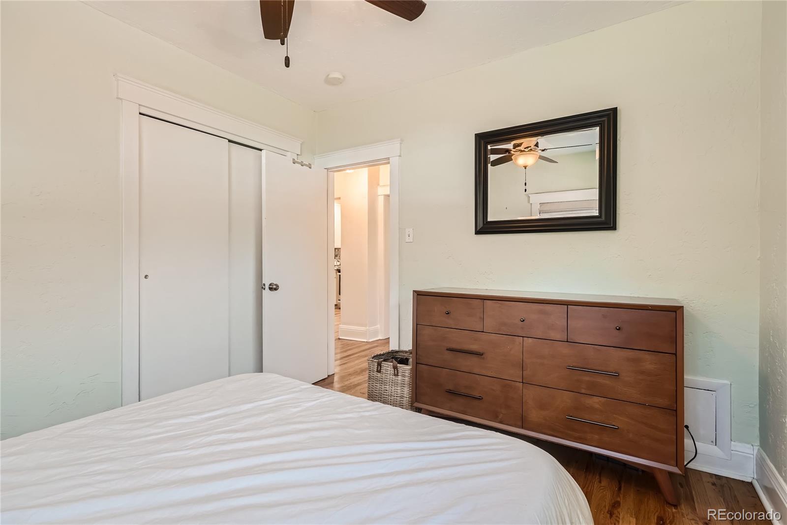 954 Monroe Street Denver, CO 80206 - Photo 18 of 28 a bedroom with a bed and a dresser