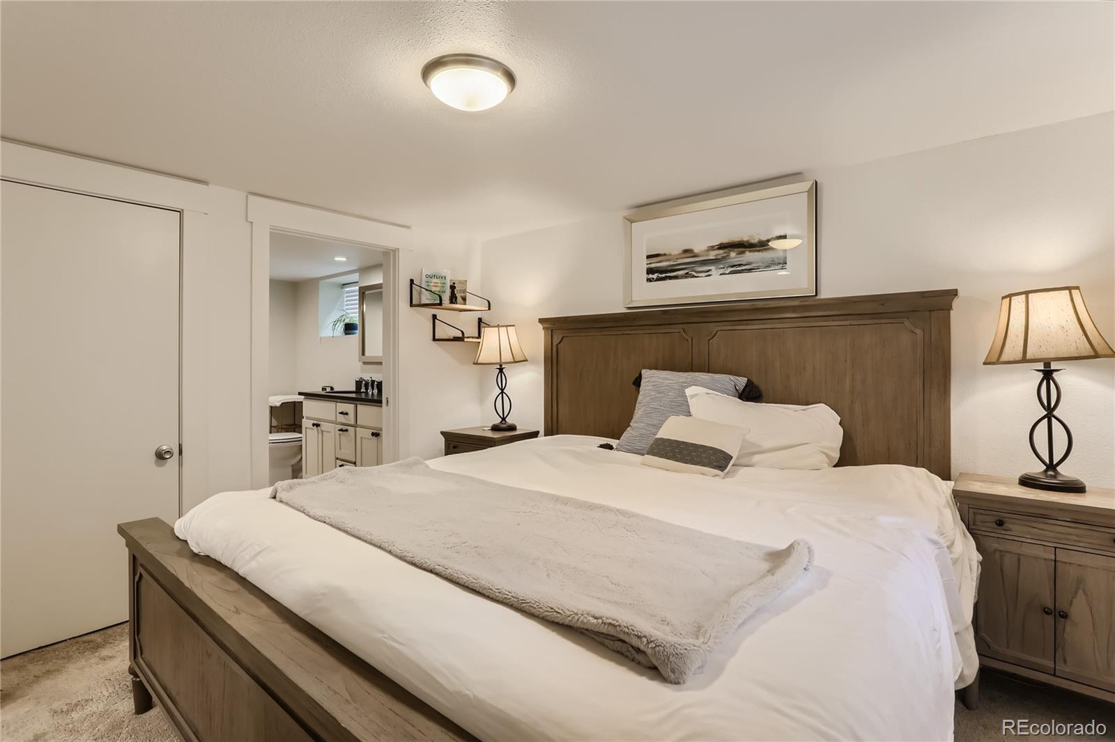 954 Monroe Street Denver, CO 80206 - Photo 22 of 28 a bedroom with a bed and a lamp on table