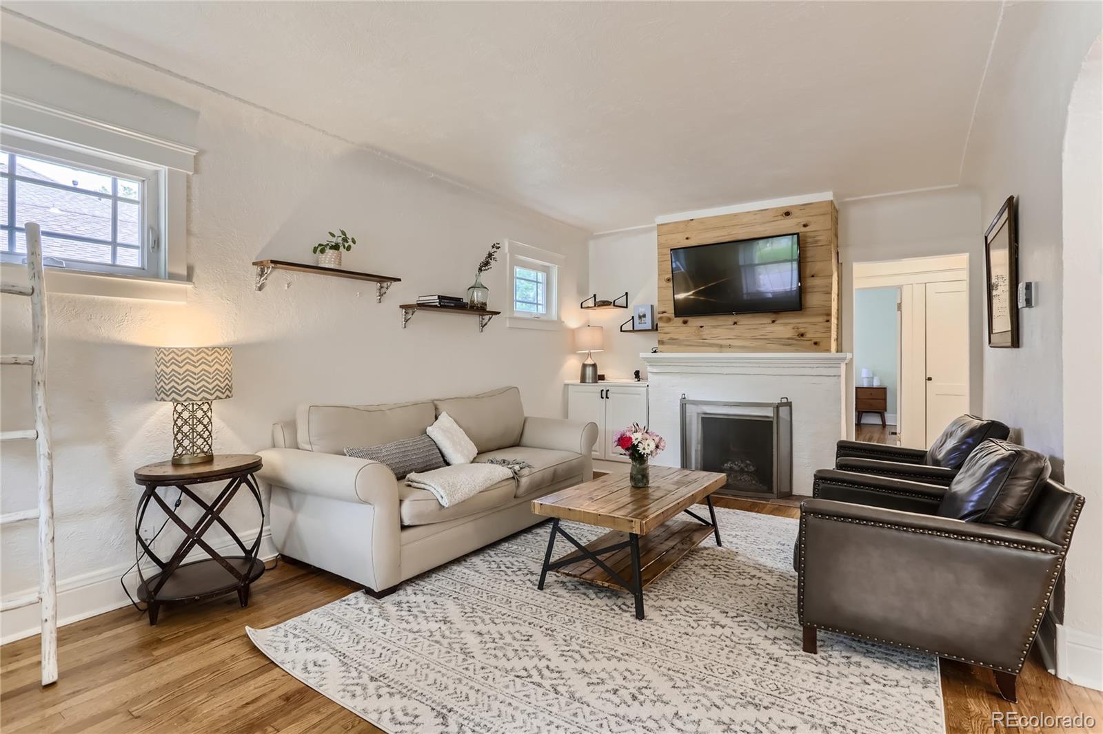 954 Monroe Street Denver, CO 80206 - Photo 6 of 28 a living room with furniture a fireplace and a flat screen tv