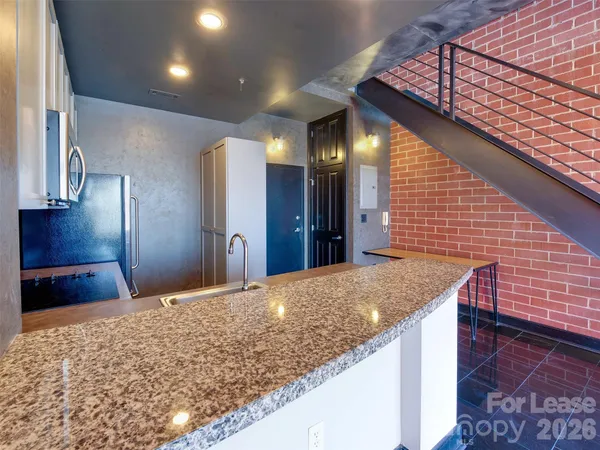 a bathroom with a granite countertop sink and a large mirror