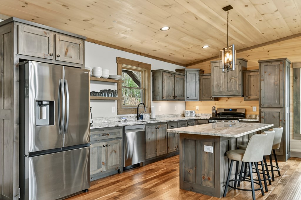 171 Cohutta Overlook Trail Blue Ridge, GA 30513 - Photo 11 of 47 a kitchen with stainless steel appliances granite countertop a refrigerator a sink dishwasher a stove and white cabinets with wooden floor