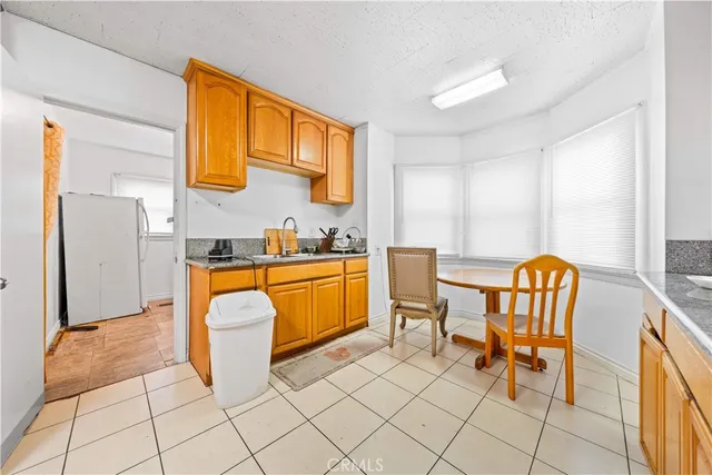 a kitchen with a sink chairs and a refrigerator