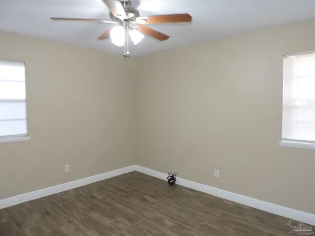 an empty room with a window and a fan