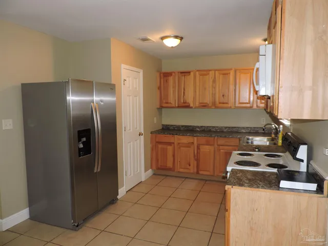 a kitchen with a refrigerator stove and cabinets