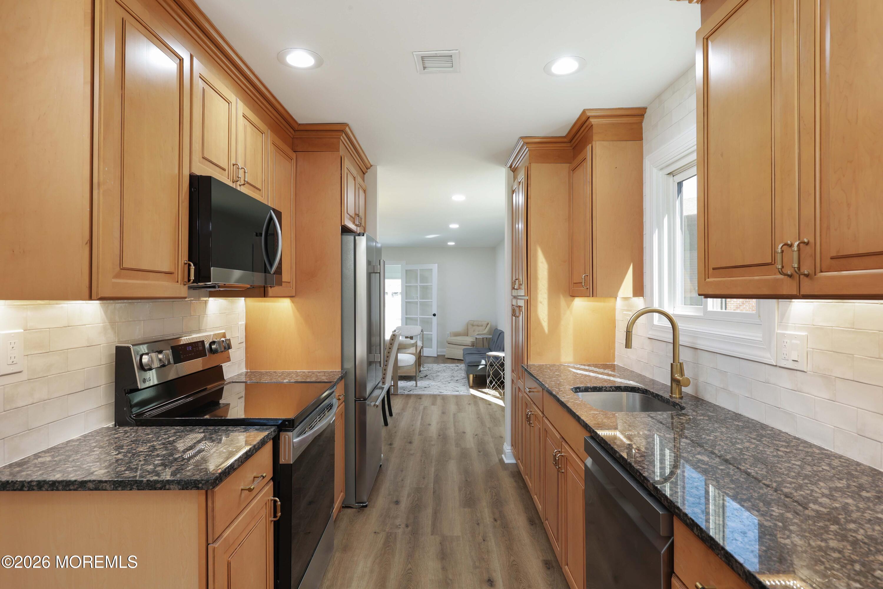 50 Hanover Court Red Bank, NJ 07701 - Photo 6 of 37 a kitchen with stainless steel appliances granite countertop a sink a stove and a wooden cabinets