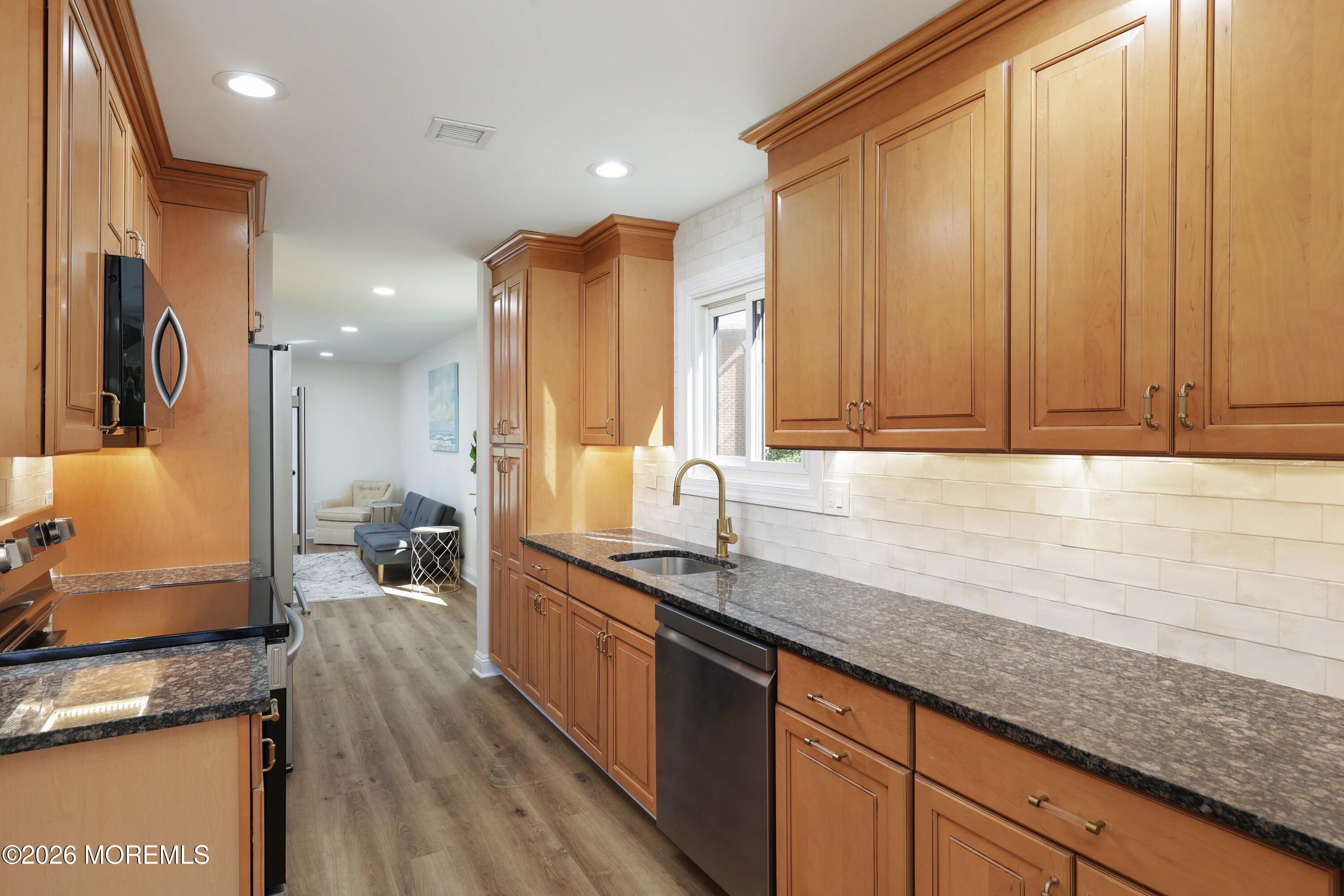 50 Hanover Court Red Bank, NJ 07701 - Photo 7 of 37 a kitchen with granite countertop a sink a stove and cabinets