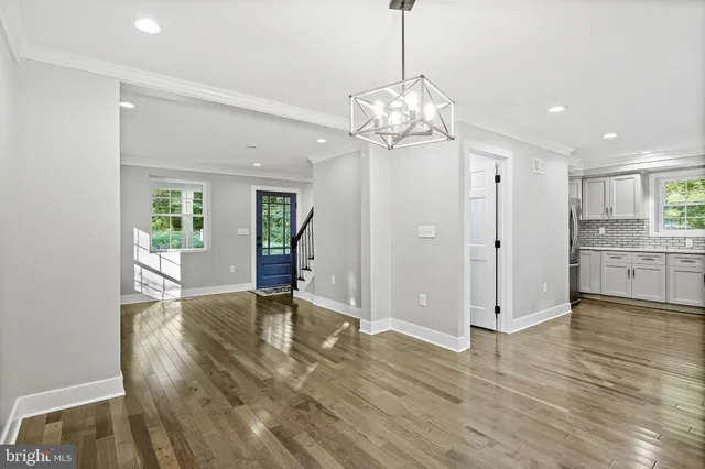 a view of a livingroom with a chandelier furniture and wooden floor