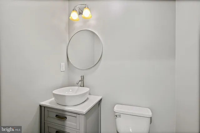 a bathroom with a sink mirror and toilet