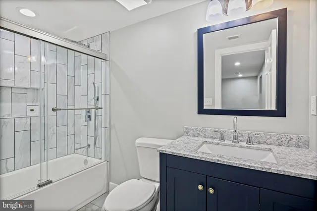 a bathroom with a granite countertop sink toilet and shower