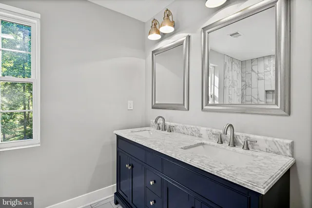 a bathroom with a granite countertop sink a light fixture and a mirror