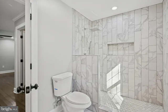 a white toilet sitting next to a shower