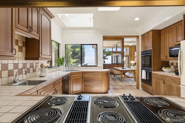 a large kitchen with stainless steel appliances a stove a sink and a granite counter tops