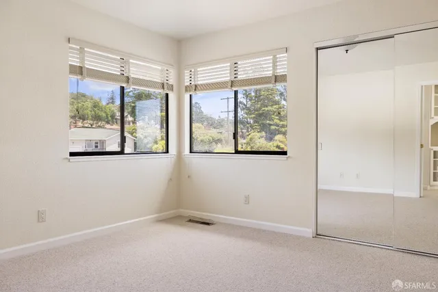 an empty room with windows and closet
