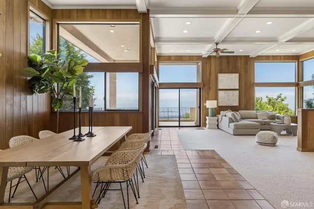 a dining room with furniture and a large window