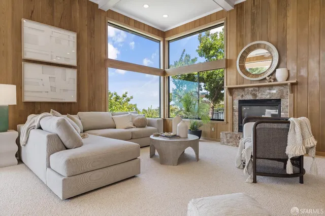 a living room with furniture a fireplace and a large window