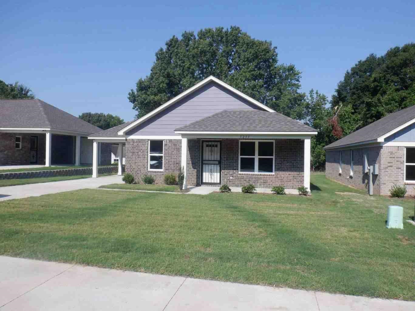 View of front facade featuring a porch, a front lawn, brick siding, and a shingled roof