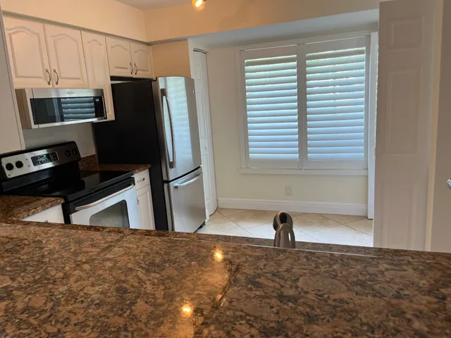 a view of a refrigerator in kitchen and living room