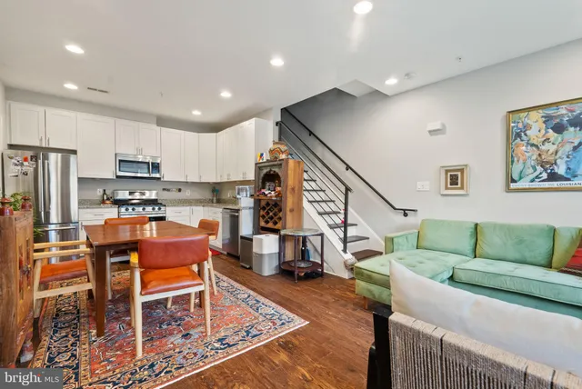a living room with lots of furniture and a kitchen view