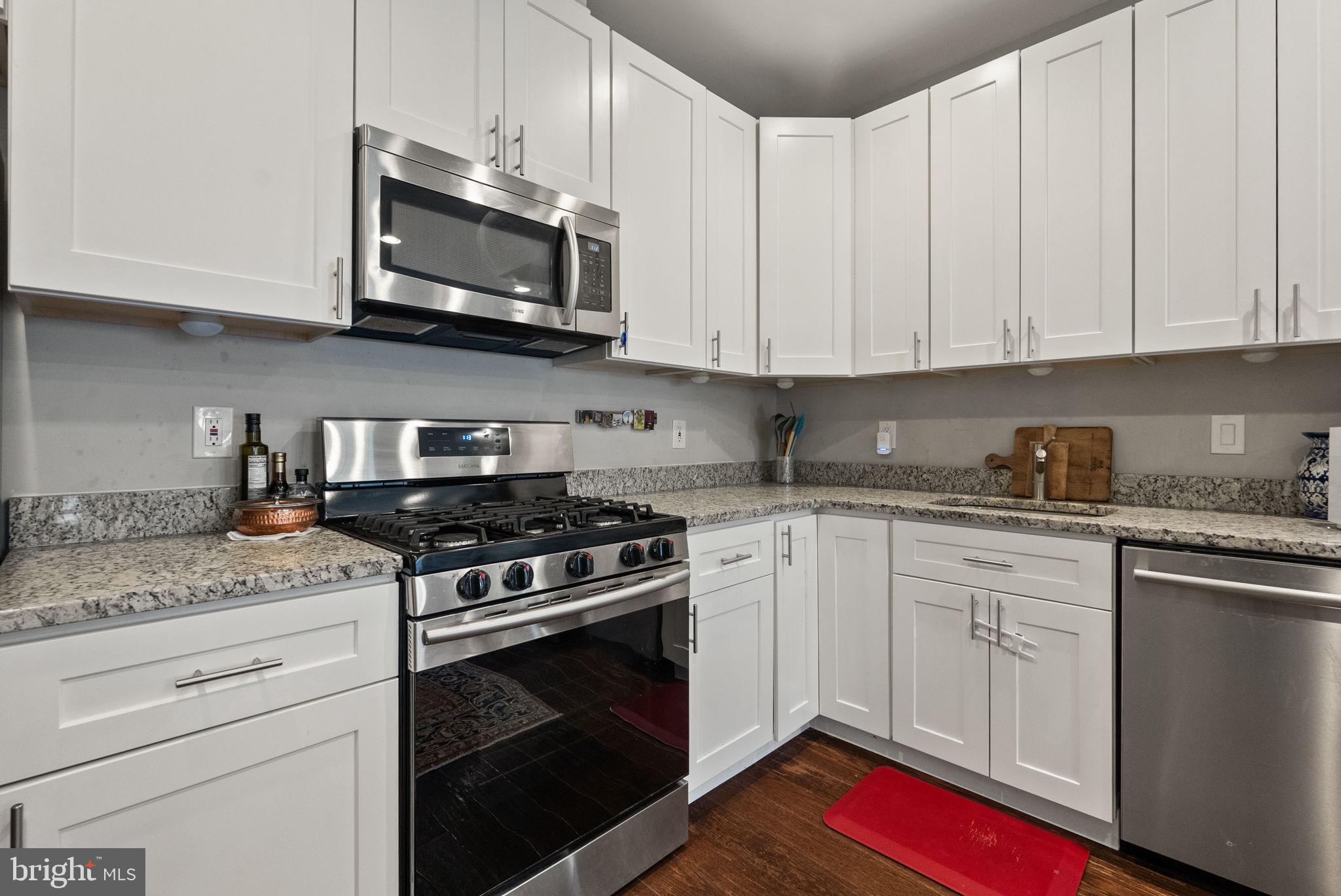 1018 13th Street Southeast, Unit 2 Washington, DC 20003 - Photo 15 of 30 a kitchen with stainless steel appliances granite countertop white cabinets and a stove top oven
