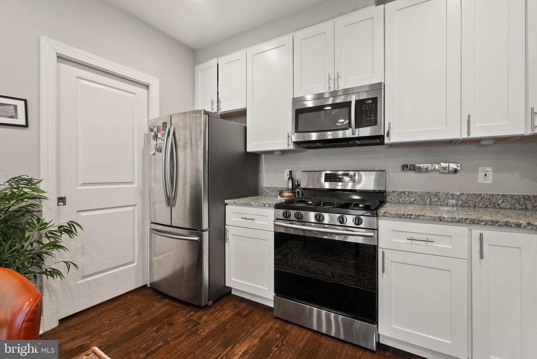 1018 13th Street Southeast, Unit 2 Washington, DC 20003 - Photo 16 of 30 a kitchen with stainless steel appliances white cabinets a stove a microwave and a hard wood floors