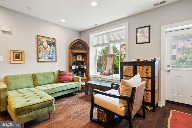 a living room with furniture and a dining table with kitchen view