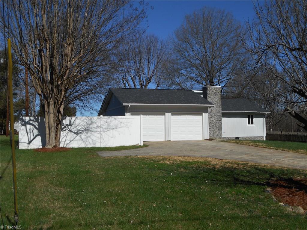 5929 Styers Ferry Road Clemmons, NC 27012 - Photo 12 of 28 In this left side view we can see more of the vinyl privacy fence that runs around the entire backyard and part of the left side also. You also have a paved driveway with a turn around.