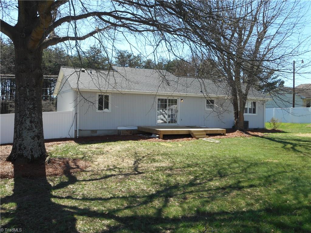 5929 Styers Ferry Road Clemmons, NC 27012 - Photo 14 of 28 In this right rear view we have a closer view of the deck, the mature trees, the new roof and the privacy fence.
