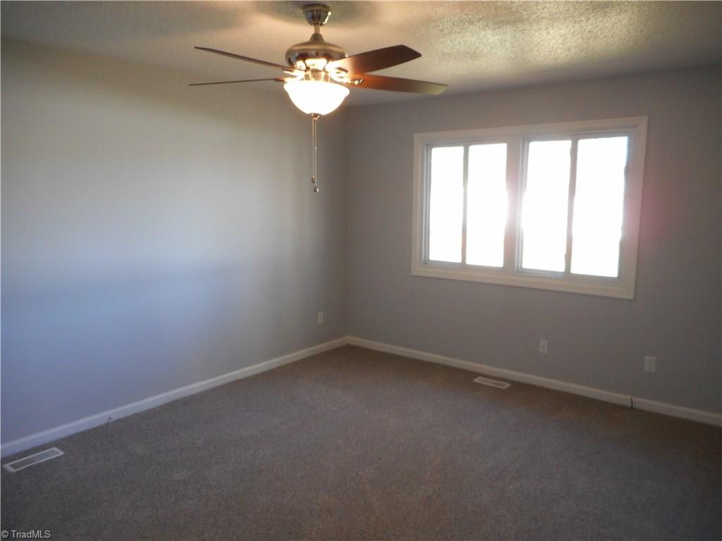 5929 Styers Ferry Road Clemmons, NC 27012 - Photo 20 of 28 In this view we are in the master bedroom. Here we can see the ceiling fan with light, the new carpet, the two new windows for natural light and the fresh new paint.