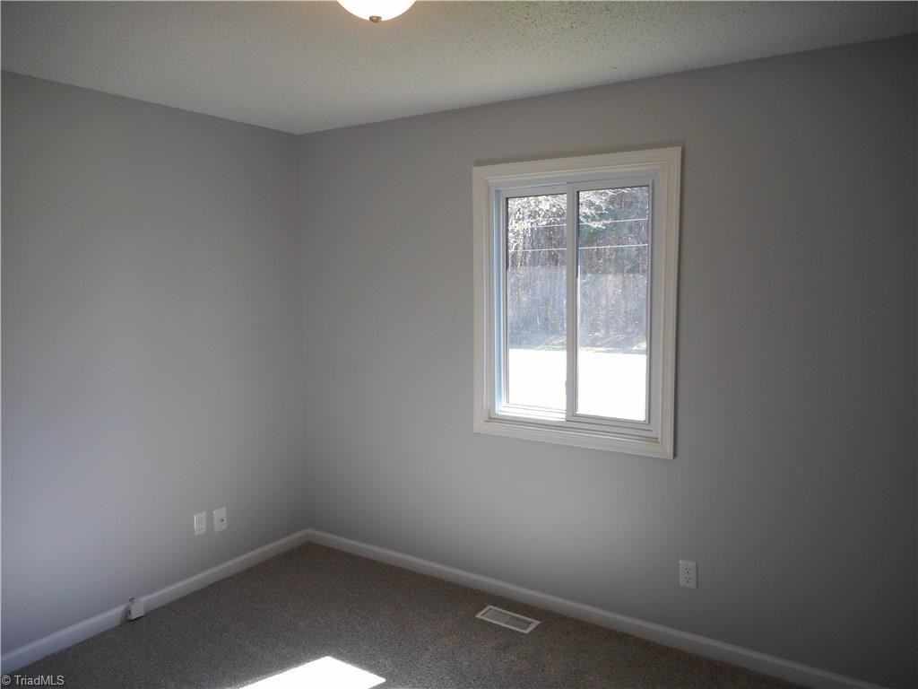 5929 Styers Ferry Road Clemmons, NC 27012 - Photo 23 of 28 Here we are in bedroom two where we can see the fresh new paint, new carpet and a window for natural light.