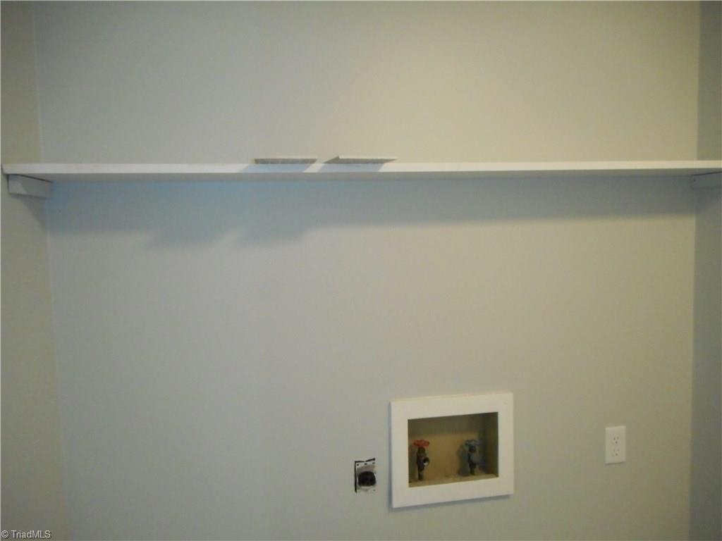 5929 Styers Ferry Road Clemmons, NC 27012 - Photo 28 of 28 Another view in the laundry room where we can see the hookups for the washer and dryer and the built-in-shelves for storing some of your laundry products up and out of the way.