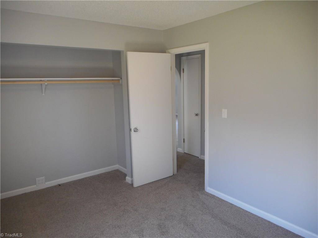 5929 Styers Ferry Road Clemmons, NC 27012 - Photo 7 of 28 Here in this view we are in bedroom two where we can see the large closet and the open door to the main hallway.