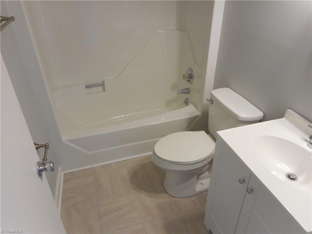 5929 Styers Ferry Road Clemmons, NC 27012 - Photo 8 of 28 In this view we are in the main hall bathroom where we can see the tile flooring for easy cleaning, the new vanity with fixtures and the fresh new paint.