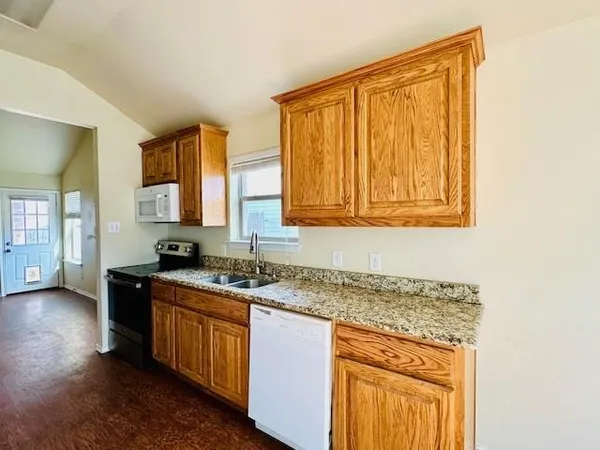 a kitchen with stainless steel appliances granite countertop a sink stove and cabinets