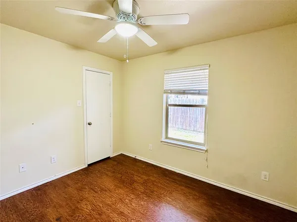 an empty room with a window and wooden floor