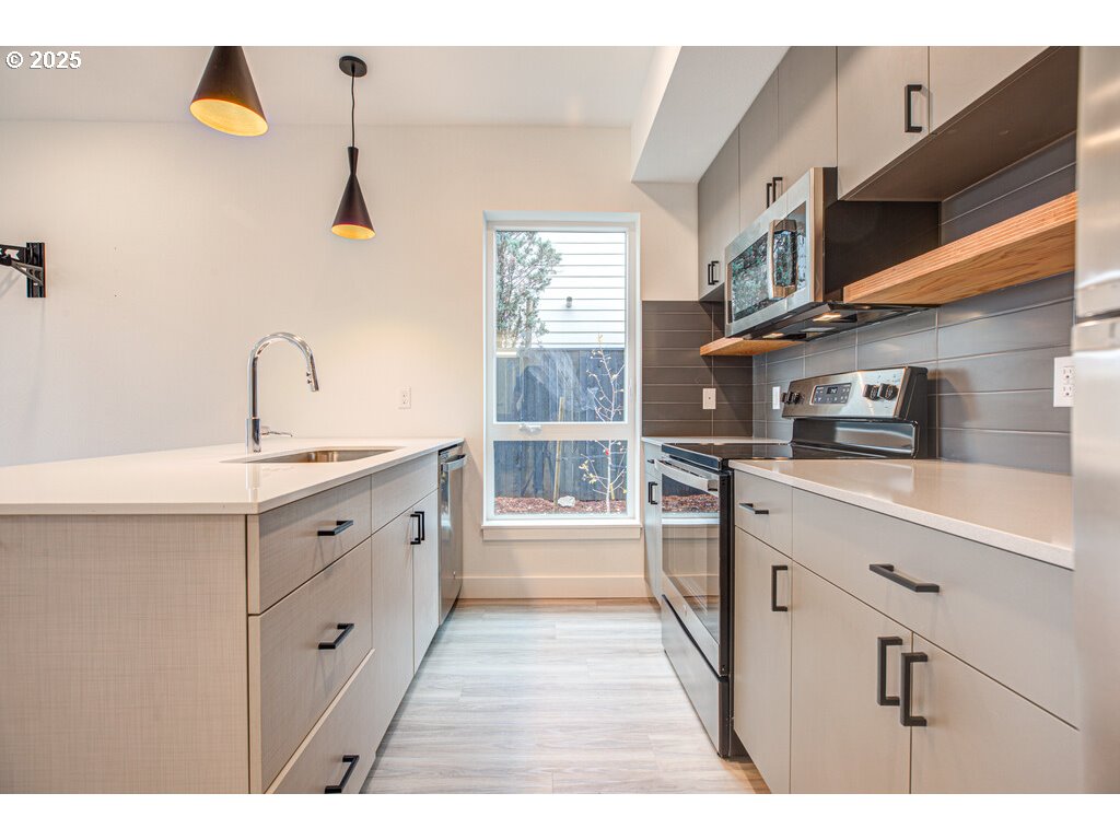 9757 Southeast Holgate Boulevard Portland, OR 97266 - Photo 15 of 16 a kitchen with granite countertop a sink stainless steel appliances and cabinets