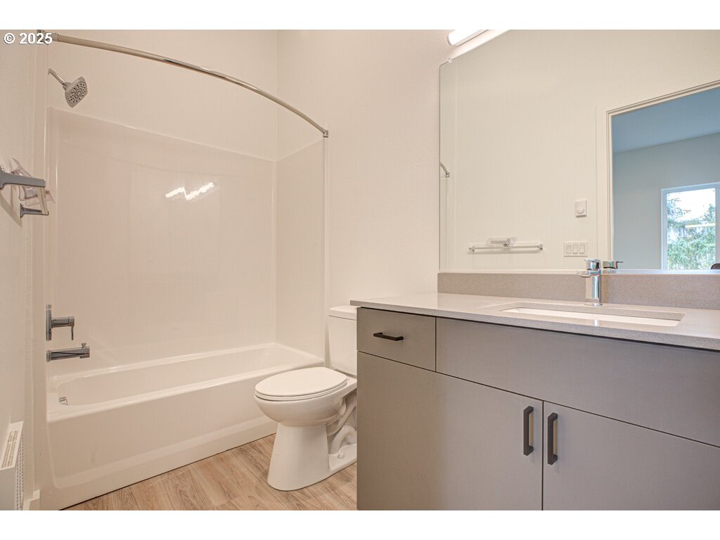 9757 Southeast Holgate Boulevard Portland, OR 97266 - Photo 16 of 16 a bathroom with a sink toilet a mirror and shower