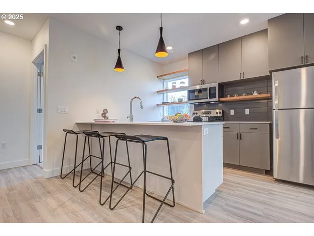 a kitchen with stainless steel appliances a sink cabinets and wooden floor