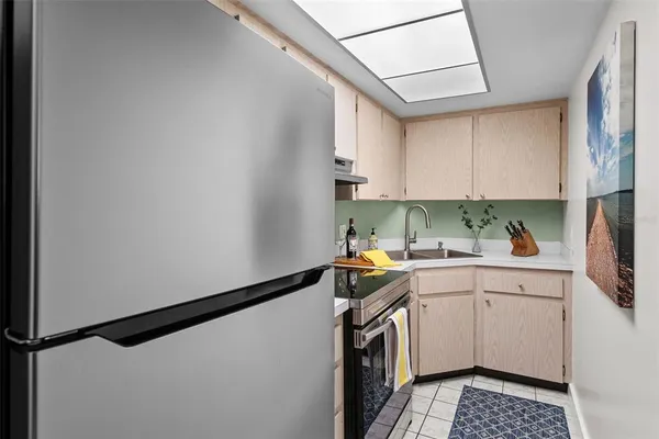 a kitchen with a sink a stove top oven and white cabinets