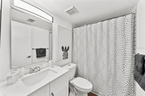 a bathroom with a sink a toilet and mirror