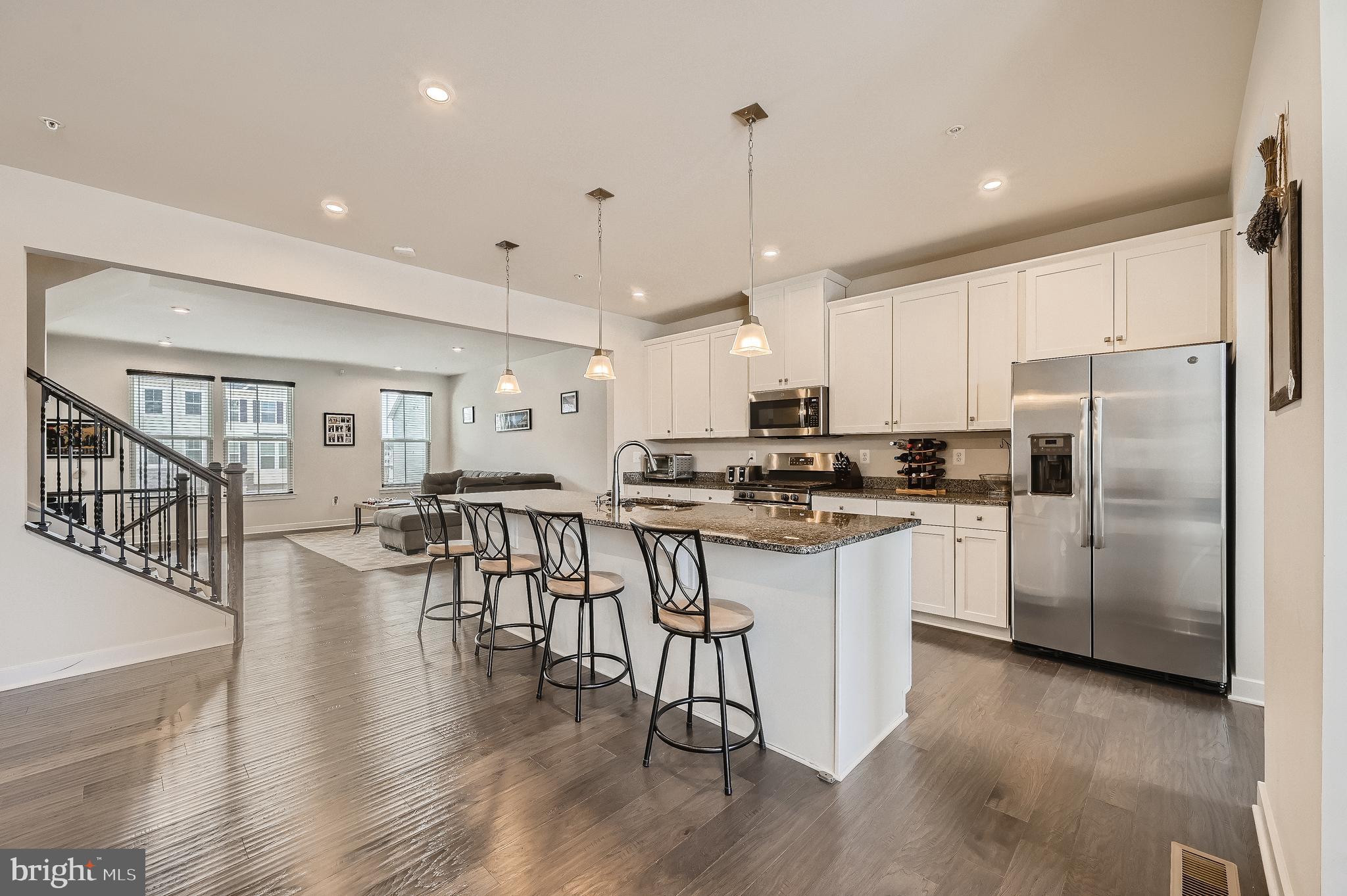 737 Iron Gate Road Bel Air, MD 21014 - Photo 8 of 27 a kitchen with stainless steel appliances granite countertop a refrigerator a stove top oven a center island a dining table and chairs with wooden floor