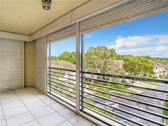 a view of a balcony with floor to ceiling windows with wooden floor