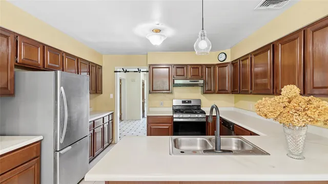 a kitchen with stainless steel appliances a stove refrigerator sink and microwave