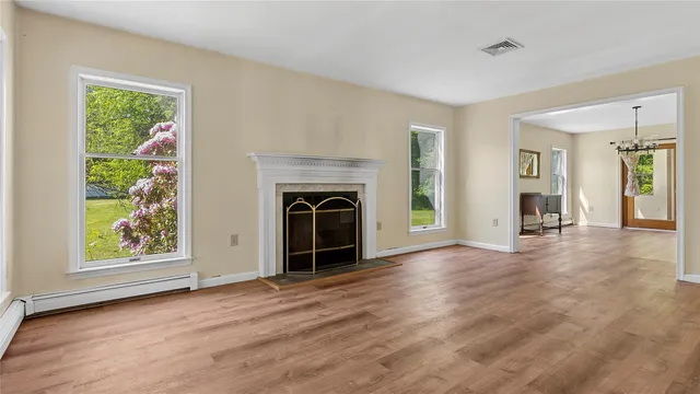 an empty room with windows and fireplace