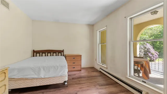 a bedroom with a bed and wooden floor