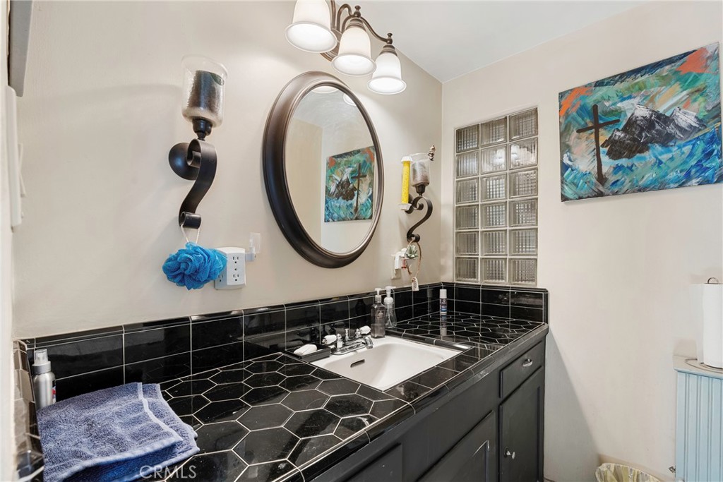 1000 1st Street Wasco, CA 93280 - Photo 23 of 75 a bathroom with a sink a vanity and a mirror