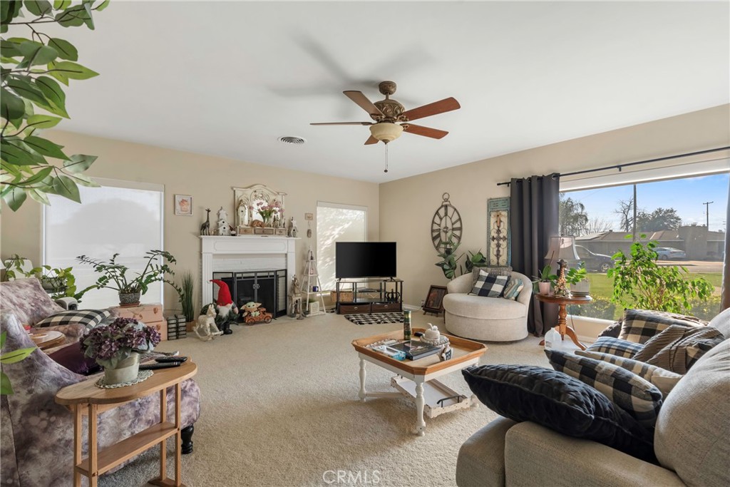 1000 1st Street Wasco, CA 93280 - Photo 8 of 75 a living room with furniture a fireplace and a potted plant