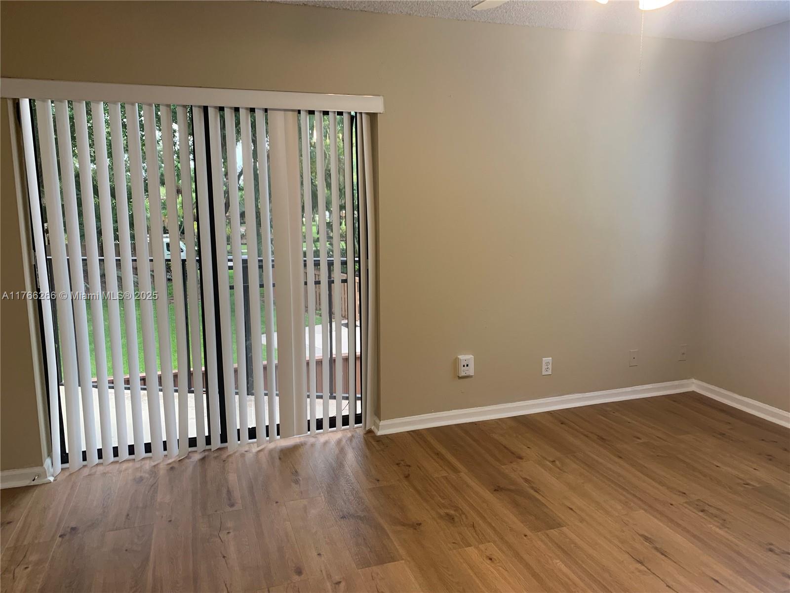 8063 Severn Drive, Unit D Boca Raton, FL 33433 - Photo 17 of 20 a view of an empty room with wooden floor and a window